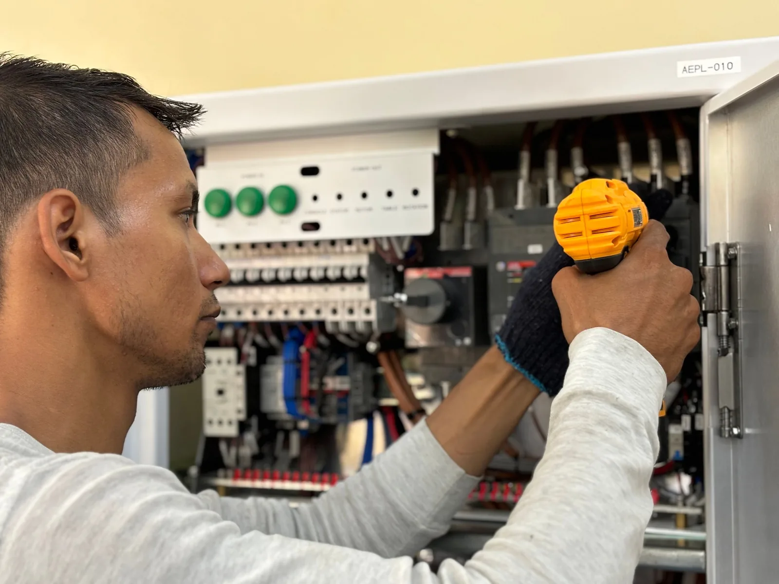 An electrician working on a commercial control panel, for subpanel installation in Cincinnati