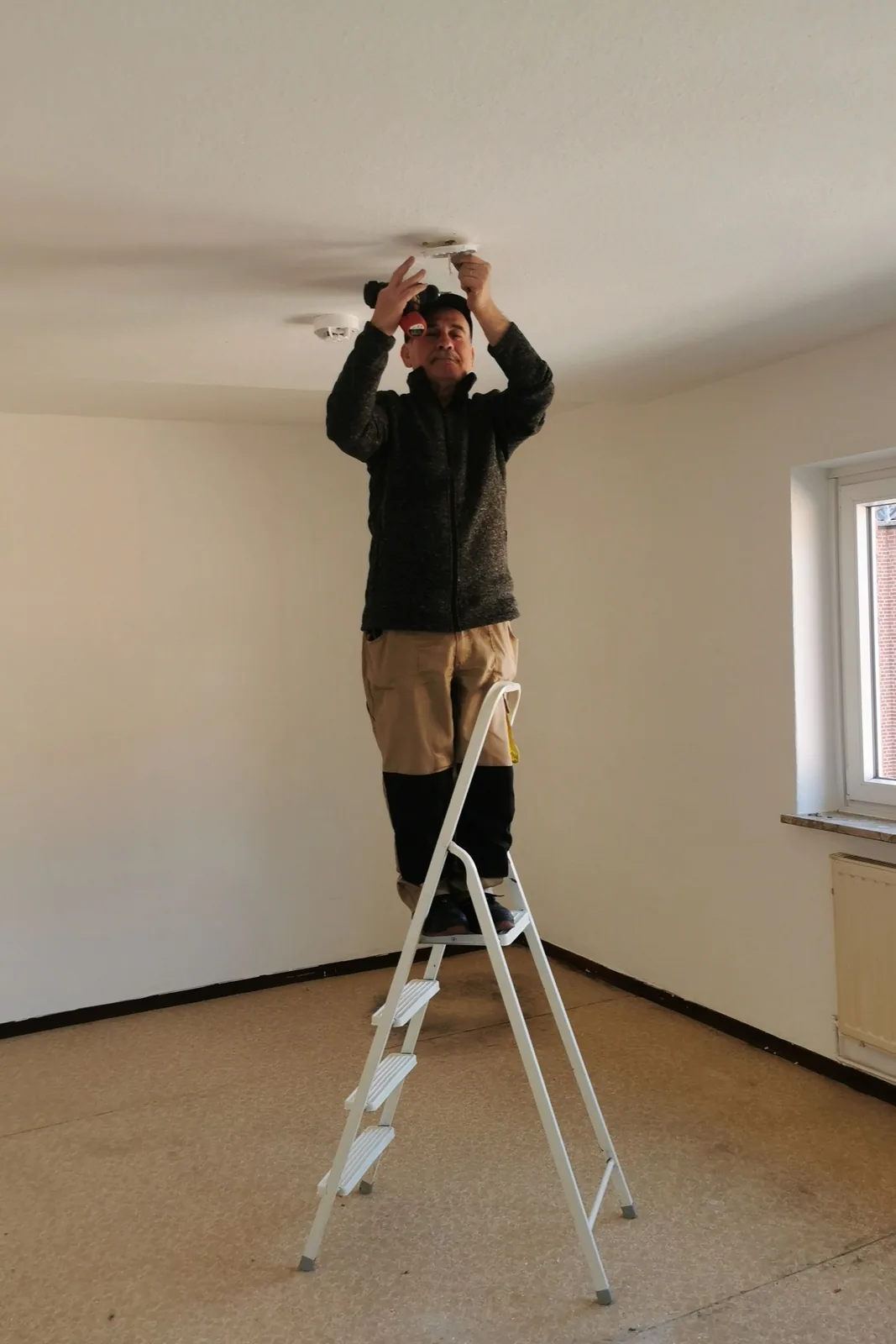 Fitting a ceiling detector from a step ladder, for ceiling fan installation in Cincinnati