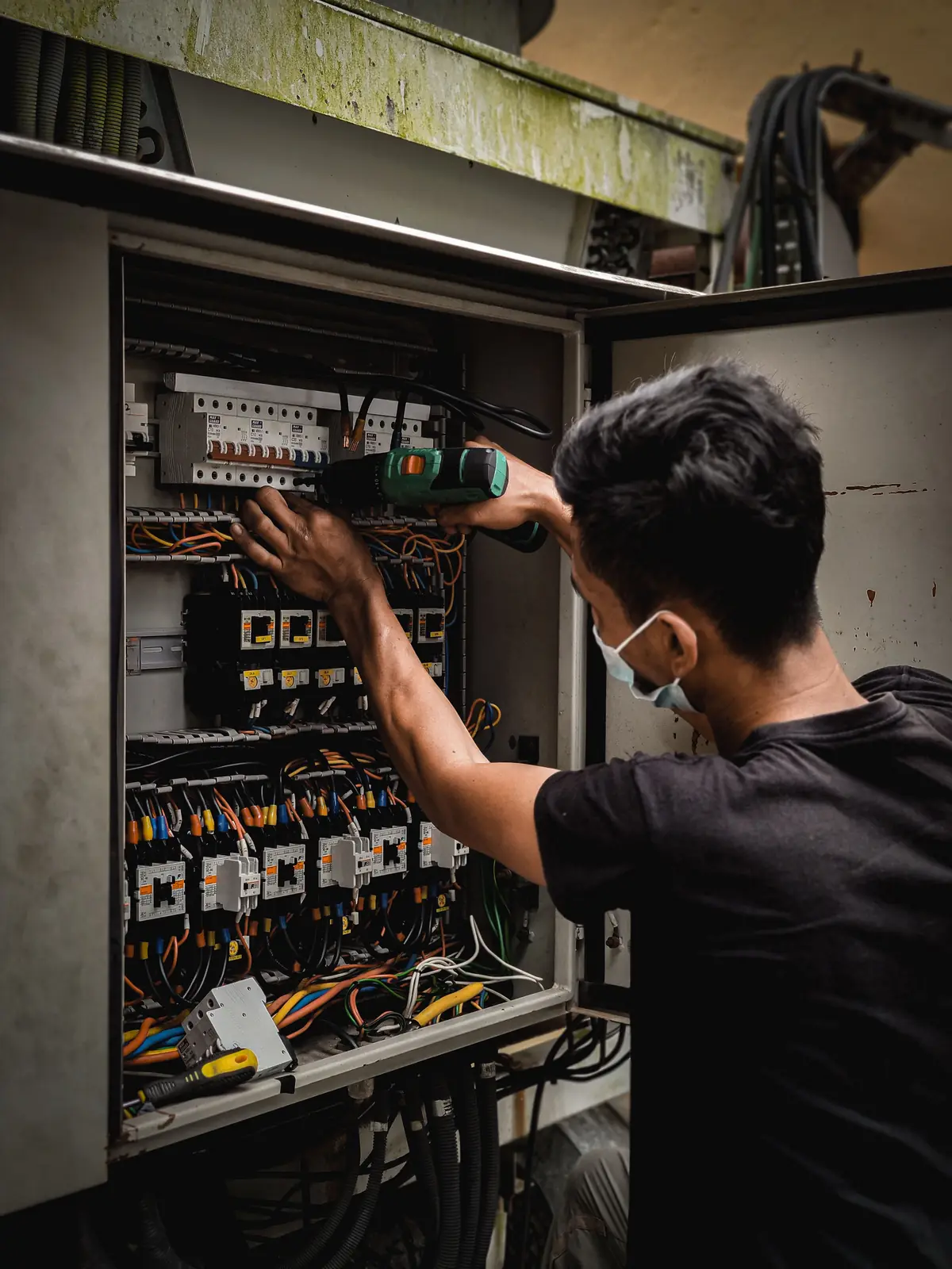 An electrician working inside a large distribution board, for commercial electrical in Cincinnati